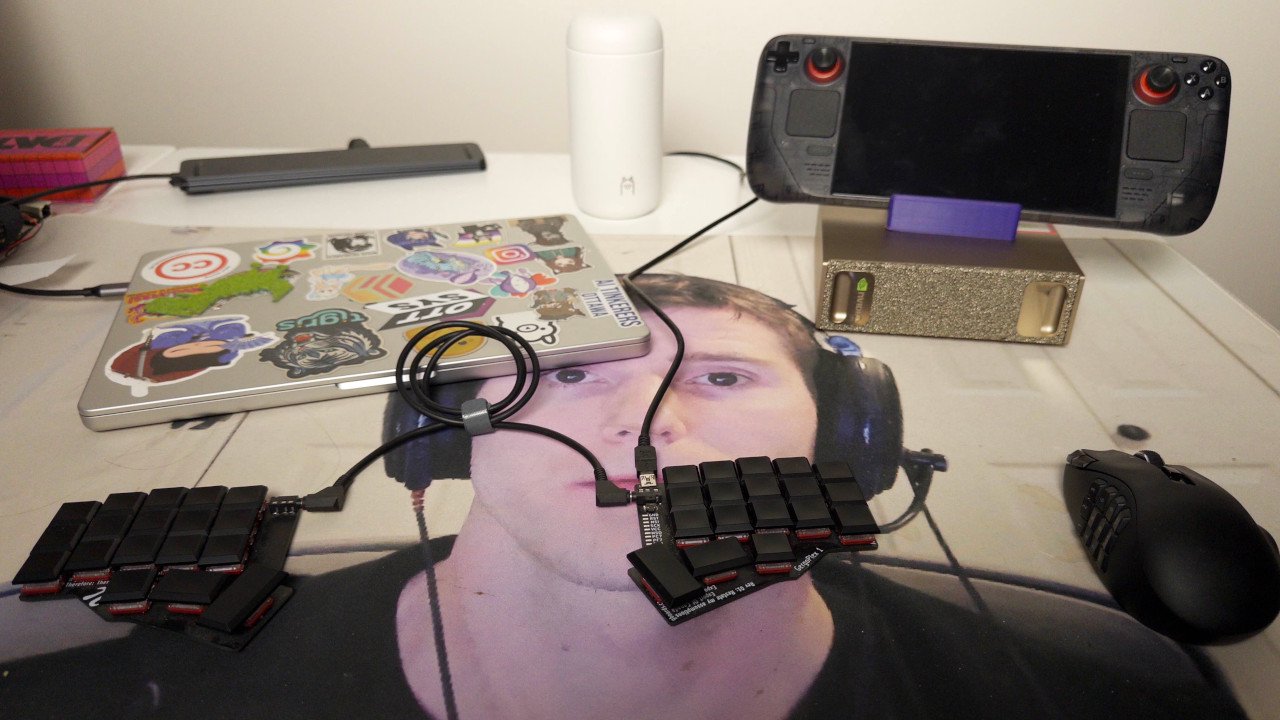 A DGX Spark on top of a desk with typical computer things around it such as a laptop, a coffee mug, a keyboard, and a mouse.