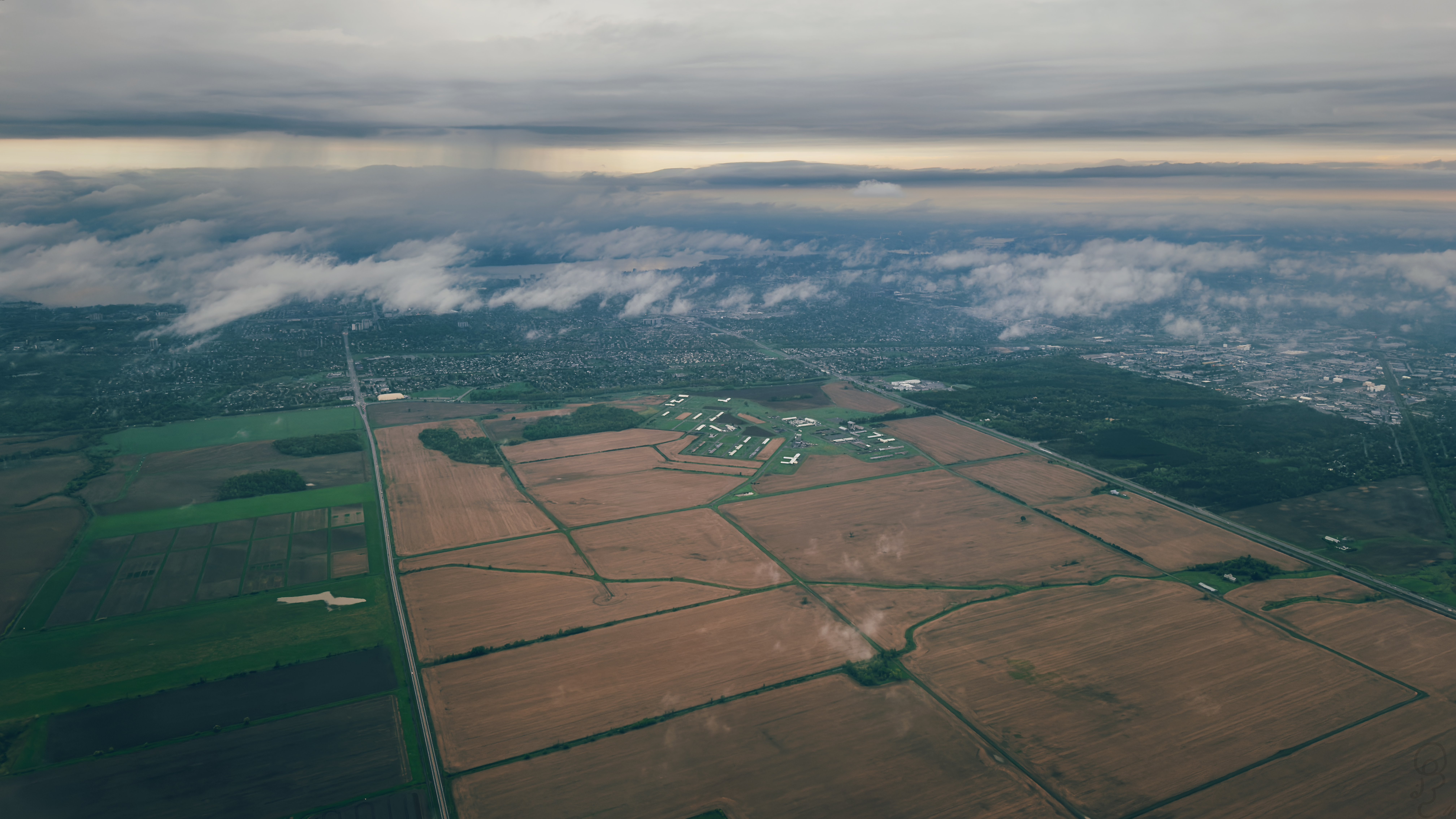 An image of A photograph of fields on the ground shot from an airplane