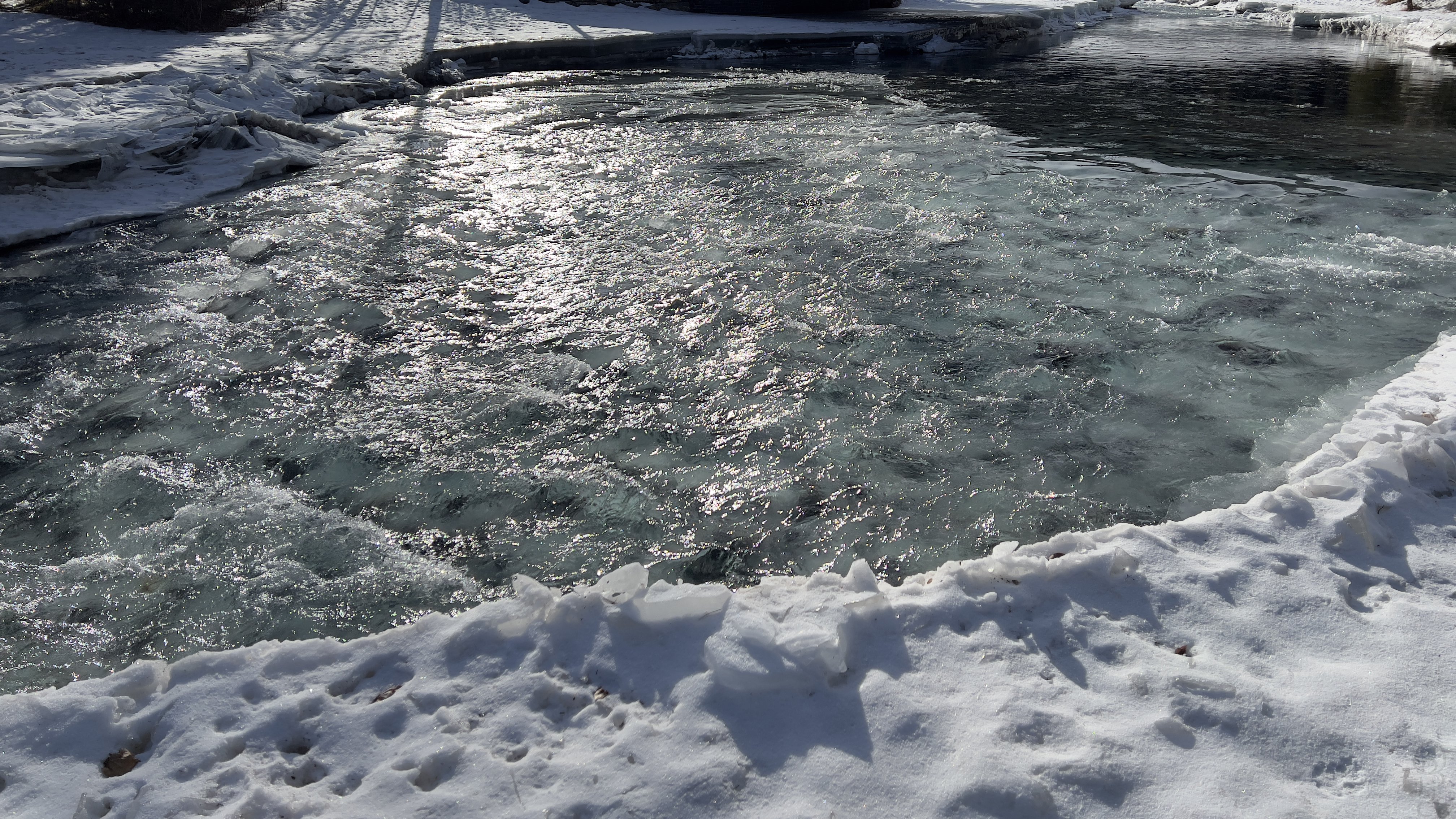 An image of A frozen river enclosed with snow