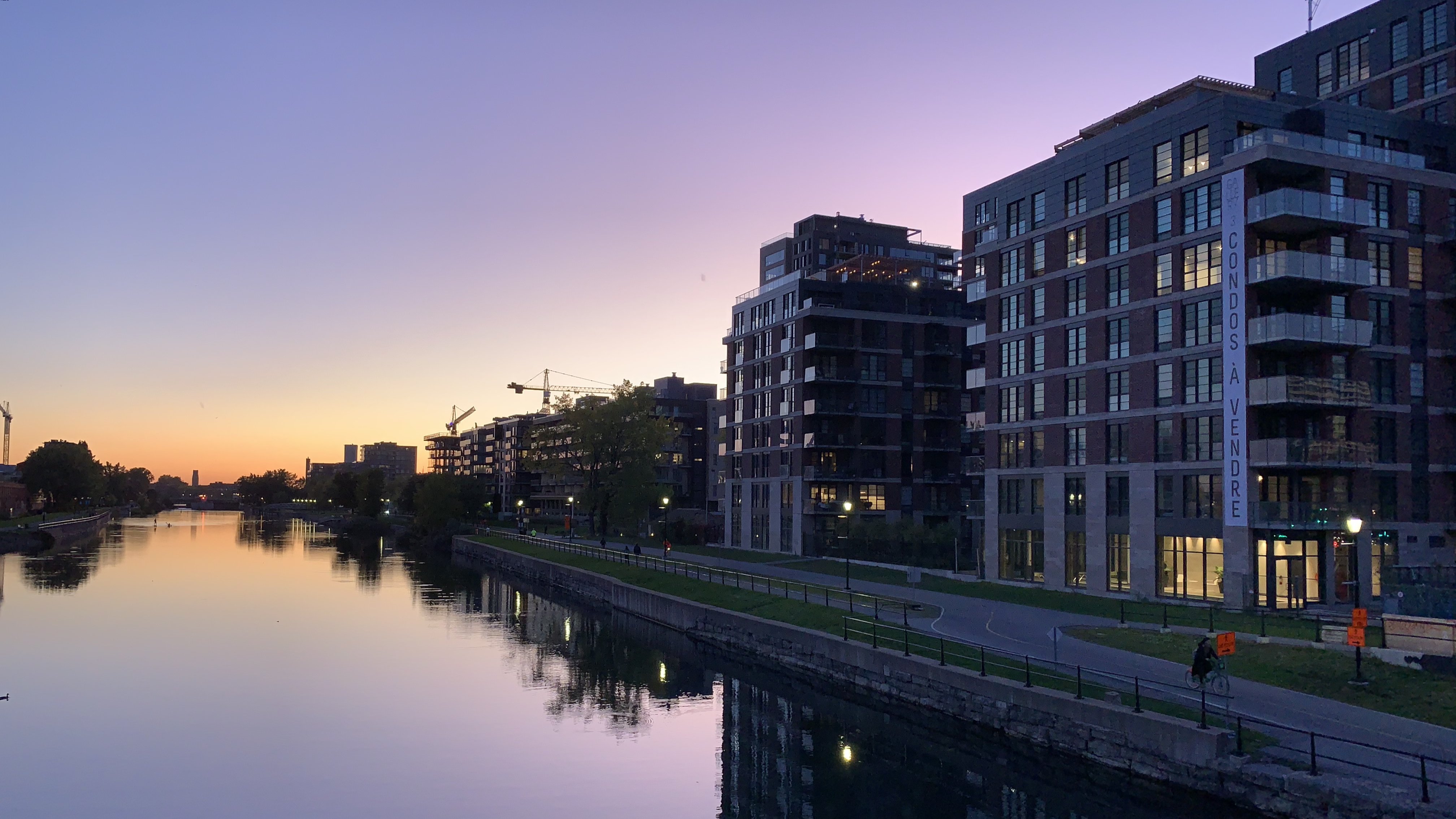 An image of A picture of a canal in Montreal near sunset when the sky turns a lovely purple.