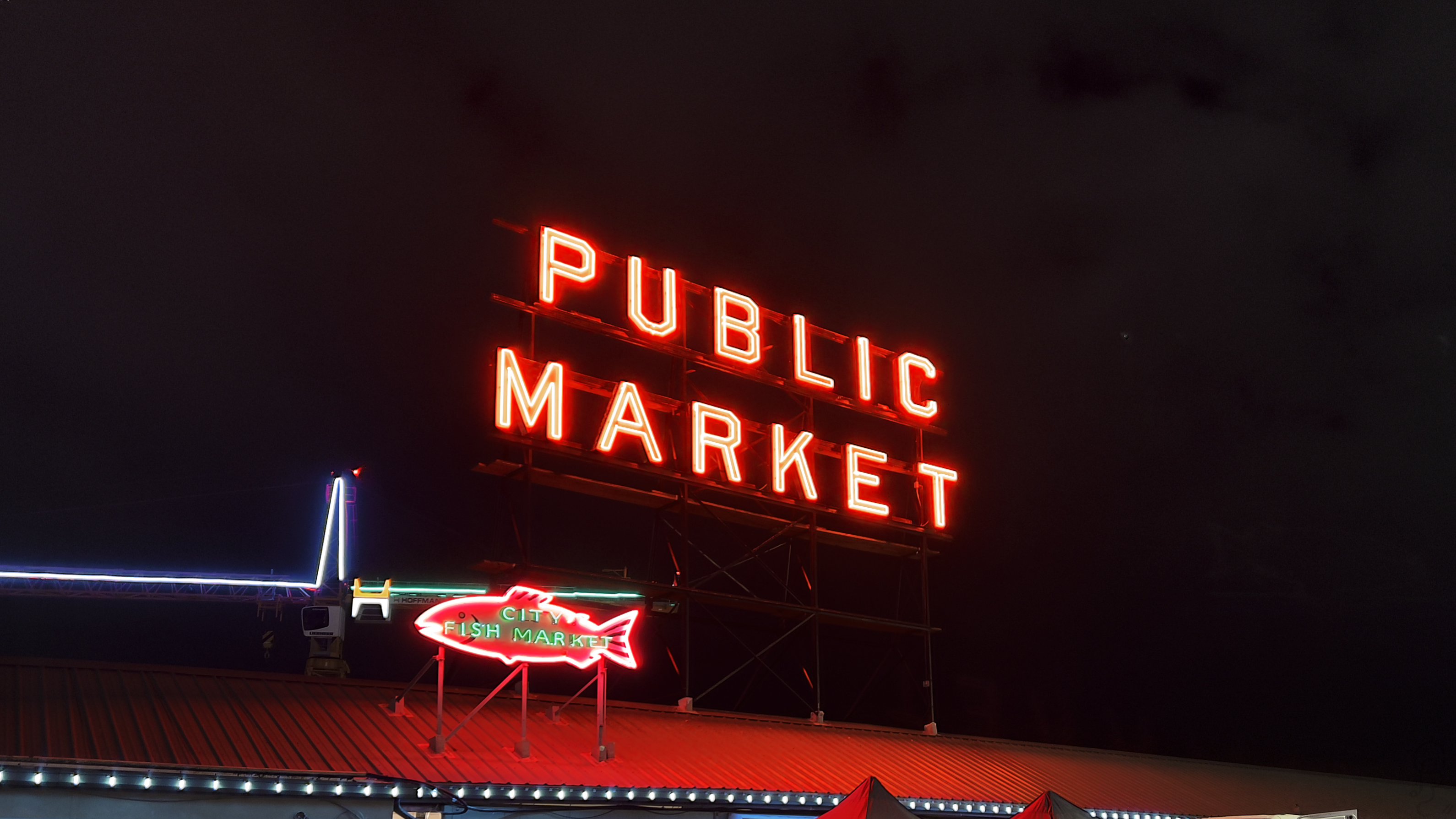 An image of The iconic Pike Place Market neon sign at night"
